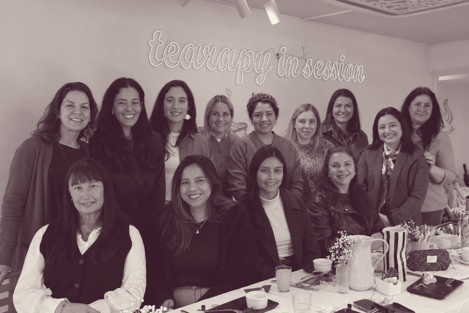 Mujeres de la comunidad Livianas reunidas en un desayuno, sonriendo alrededor de una mesa